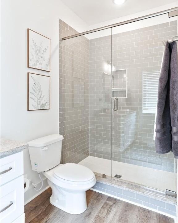 1062 Hunters Way, Opelika, AL 36801 - bathroom featuring vanity, a shower stall, and wood finished floors