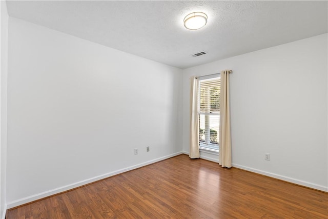 spare room with hardwood / wood-style floors and a textured ceiling