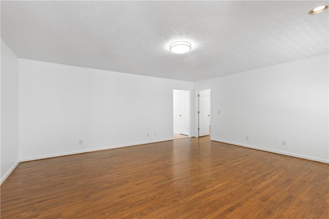 unfurnished room with dark wood-type flooring