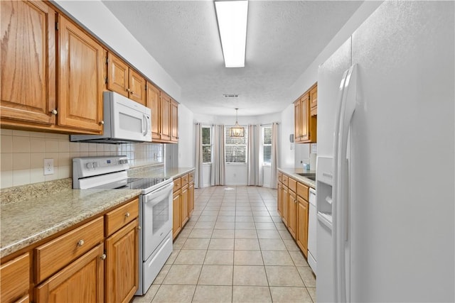 kitchen with decorative backsplash, a textured ceiling, white appliances, decorative light fixtures, and light tile patterned flooring