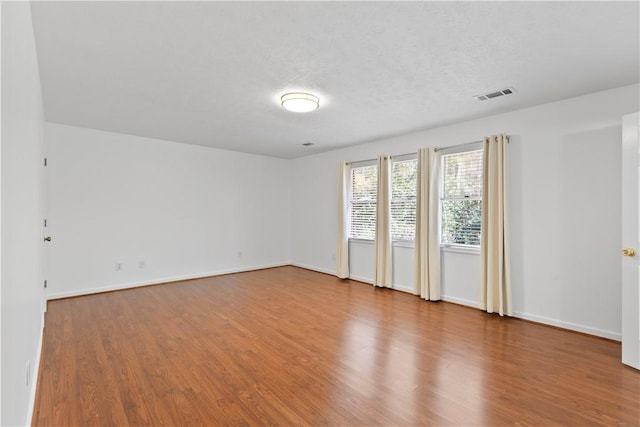 spare room with wood-type flooring and a textured ceiling