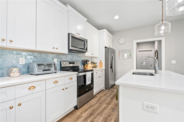 1242 Burrow Cir, Opelika, AL 36801 - kitchen with stainless steel appliances, a sink, light countertops, white cabinets, and backsplash