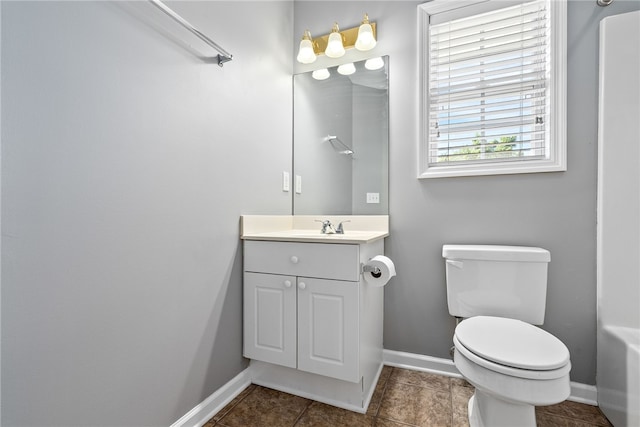 bathroom featuring vanity, toilet, and baseboards