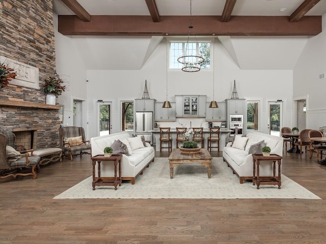 living room featuring high vaulted ceiling, a stone fireplace, and beamed ceiling