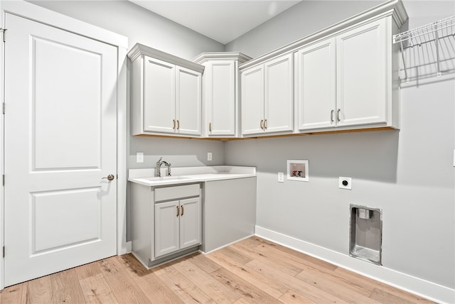 laundry area with electric dryer hookup, baseboards, cabinet space, and light wood-style flooring