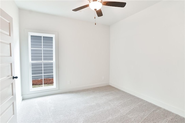 carpeted empty room featuring a ceiling fan and baseboards