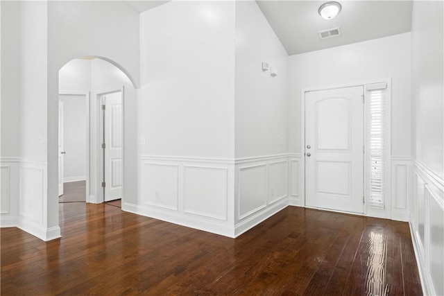 2711 Tara Ct, Opelika, AL 36804 - foyer featuring a decorative wall, arched walkways, a wainscoted wall, dark wood finished floors, and vaulted ceiling