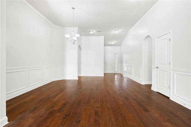 2711 Tara Ct, Opelika, AL 36804 - unfurnished room featuring arched walkways, a chandelier, a wainscoted wall, dark wood-style floors, and a decorative wall