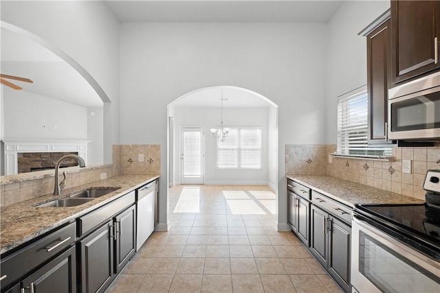 2711 Tara Ct, Opelika, AL 36804 - kitchen with stainless steel appliances, backsplash, healthy amount of natural light, light stone counters, and a towering ceiling