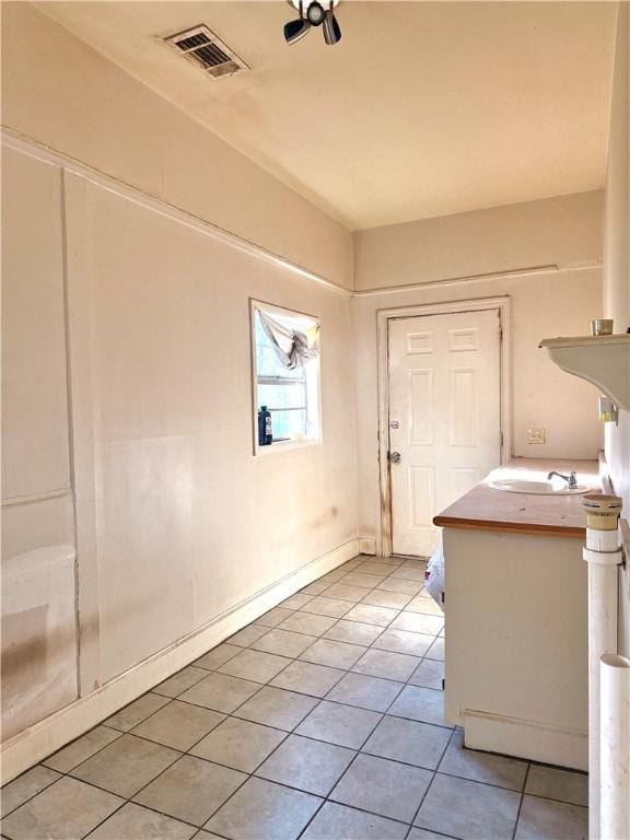 interior space with light tile patterned flooring and sink