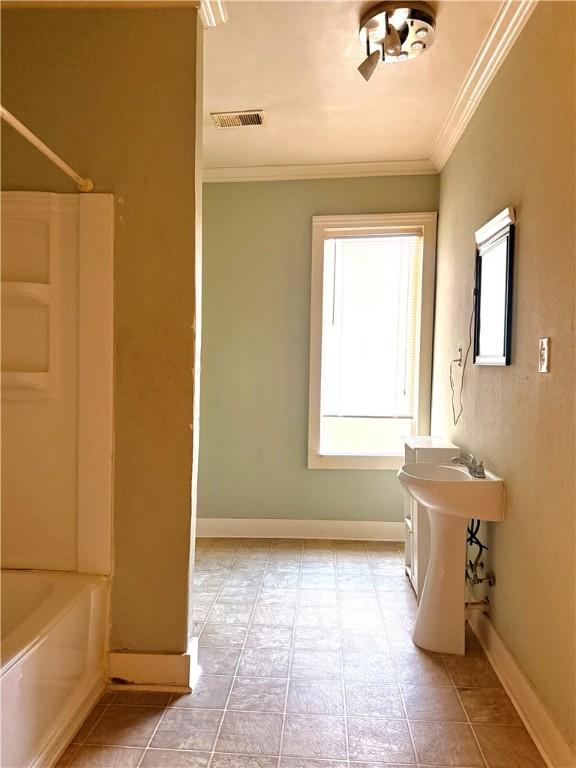 bathroom featuring ornamental molding and shower / washtub combination