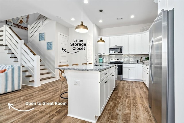 617 Cameron Ct, Auburn, AL 36830 - kitchen with stainless steel appliances, a sink, wood finished floors, light stone countertops, and recessed lighting