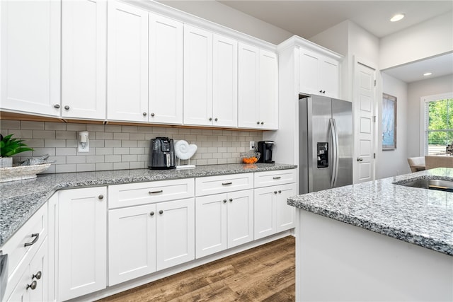 617 Cameron Ct, Auburn, AL 36830 - kitchen with stainless steel refrigerator with ice dispenser, wood finished floors, a sink, white cabinets, and decorative backsplash
