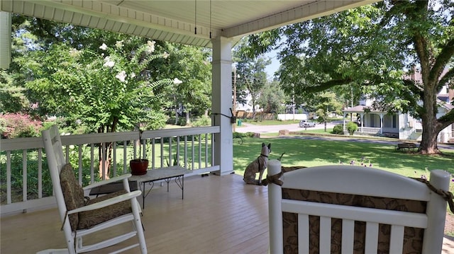 deck featuring a yard and covered porch