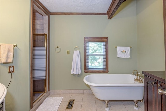 full bathroom with a freestanding bath, ornamental molding, a shower stall, a textured ceiling, and tile patterned floors