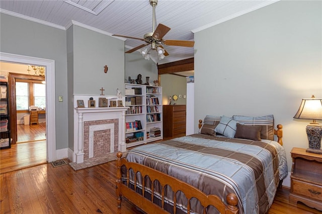 bedroom with ornamental molding, a fireplace, and hardwood / wood-style flooring