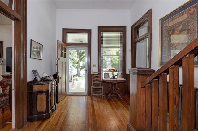 entrance foyer featuring stairway, crown molding, and wood-type flooring