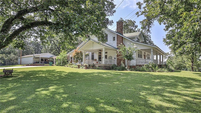 view of front of house featuring a front yard, a porch, a ceiling fan, and a chimney