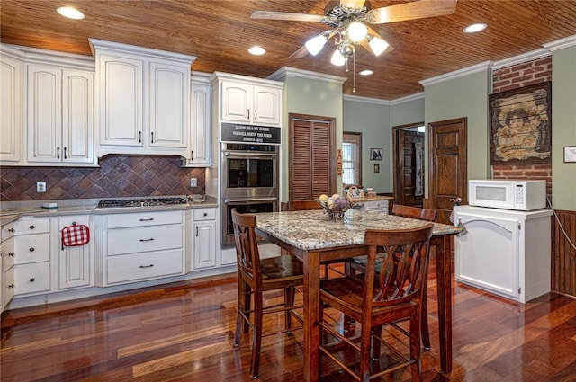 kitchen featuring white cabinetry, wooden ceiling, appliances with stainless steel finishes, and ornamental molding