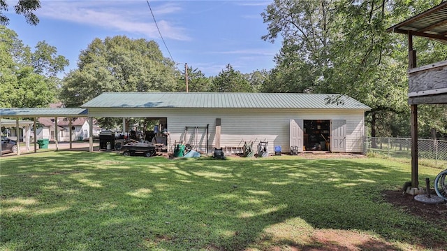 back of property featuring metal roof, a lawn, a carport, and fence