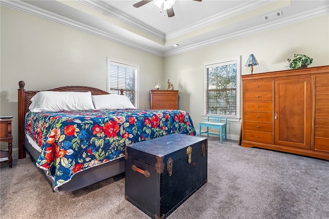 bedroom featuring multiple windows, a tray ceiling, crown molding, and carpet