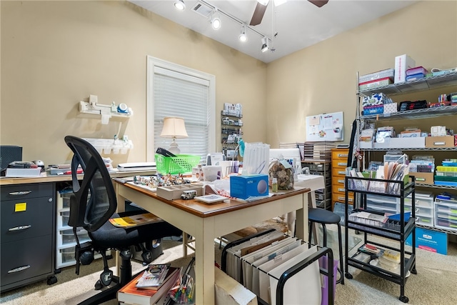 carpeted office space featuring rail lighting and ceiling fan