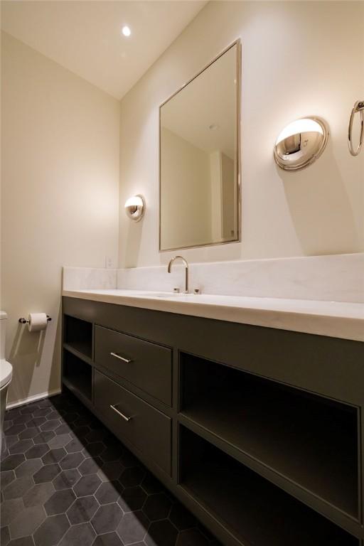 bathroom featuring tile patterned flooring, vanity, and toilet