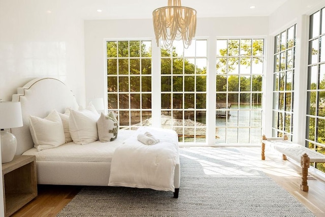 bedroom with hardwood / wood-style flooring and a notable chandelier