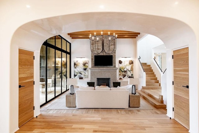 living room featuring beam ceiling and light hardwood / wood-style flooring