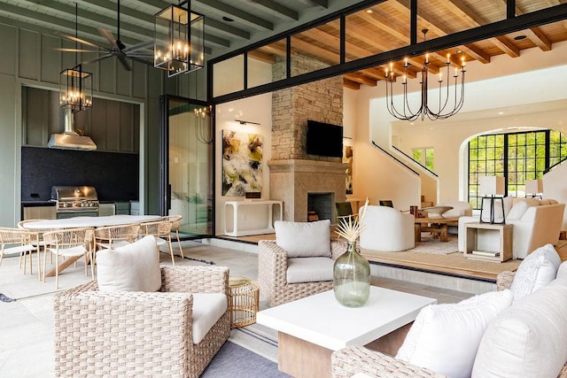 living room with wood ceiling, ceiling fan, high vaulted ceiling, beamed ceiling, and a fireplace