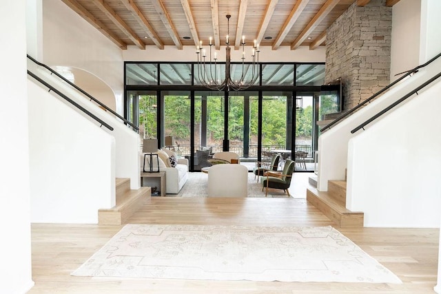 interior space featuring beamed ceiling, a high ceiling, light hardwood / wood-style floors, and wood ceiling