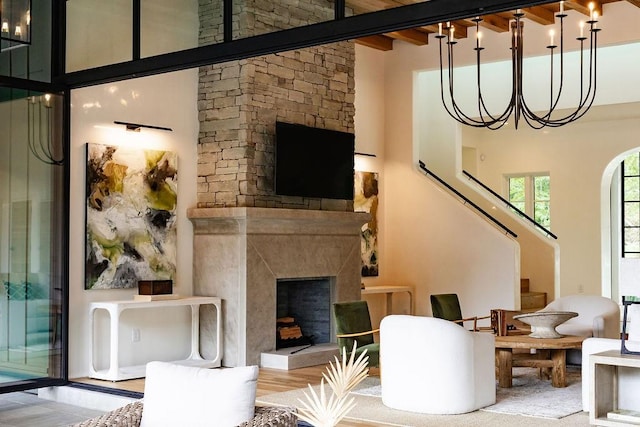 living room featuring hardwood / wood-style flooring, beam ceiling, a fireplace, and a high ceiling