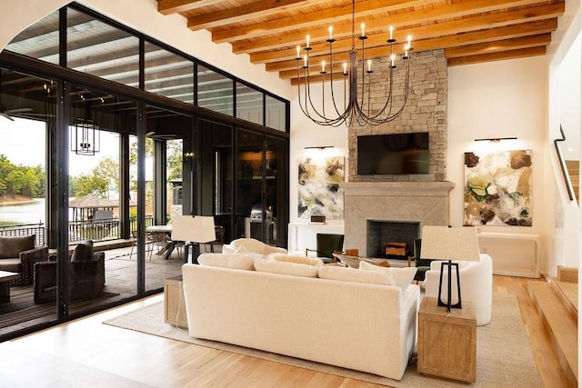 living room with wood ceiling, a large fireplace, beam ceiling, a chandelier, and hardwood / wood-style floors