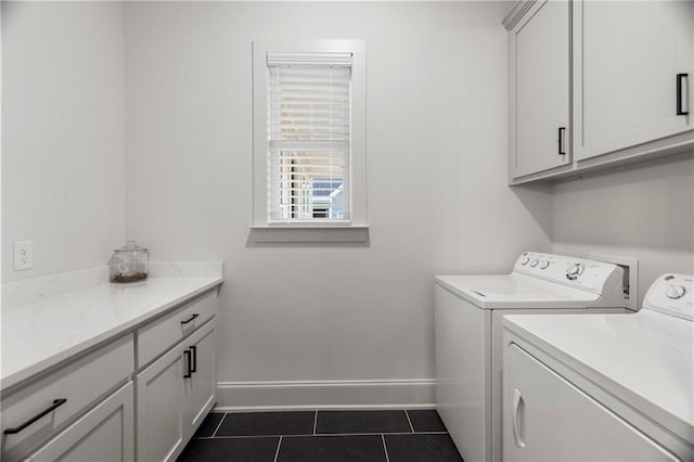 washroom featuring cabinets, dark tile patterned floors, and washer and dryer
