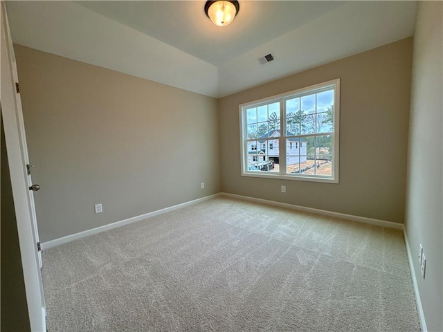 empty room featuring light carpet and vaulted ceiling