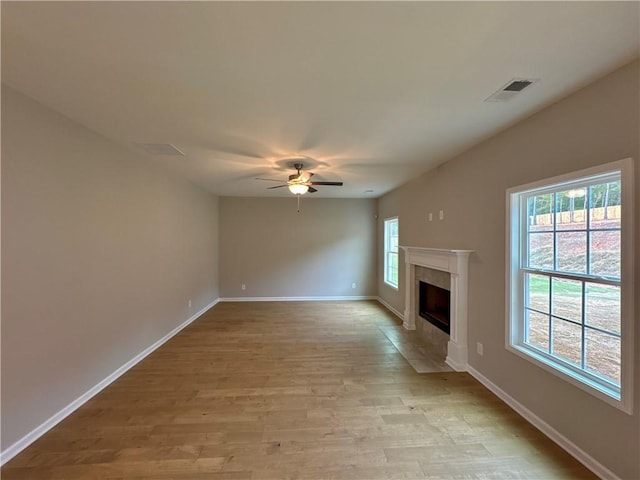 unfurnished living room featuring light wood-type flooring, ceiling fan, and a healthy amount of sunlight