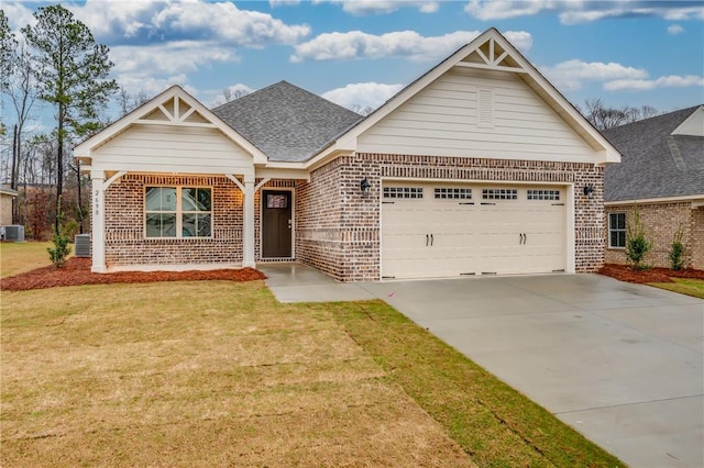 view of front of house with a garage, central AC, and a front lawn