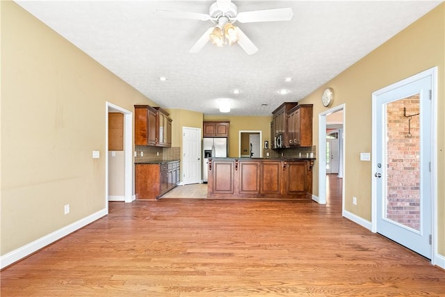 1817 Roanoke Ln, Auburn, AL 36830 - kitchen with dark countertops, appliances with stainless steel finishes, decorative backsplash, light wood-type flooring, and a ceiling fan