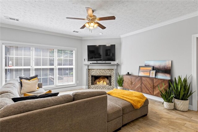 1630 Academy Dr Unit 402, Auburn, AL 36830 - living room featuring hardwood / wood-style flooring, ceiling fan, a fireplace, ornamental molding, and a textured ceiling