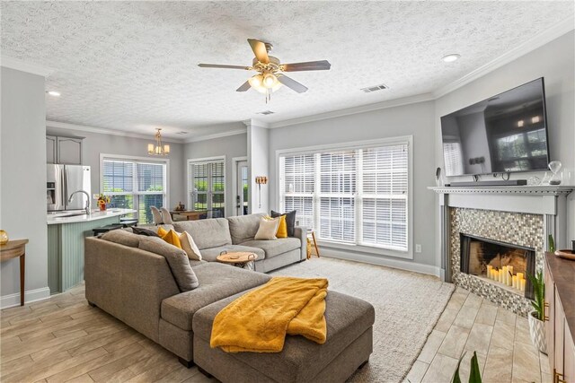 1630 Academy Dr Unit 402, Auburn, AL 36830 - living area with light wood-type flooring, a chandelier, ceiling fan, a fireplace, and a textured ceiling