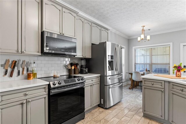 1630 Academy Dr Unit 402, Auburn, AL 36830 - kitchen with appliances with stainless steel finishes, gray cabinets, crown molding, tasteful backsplash, and light countertops