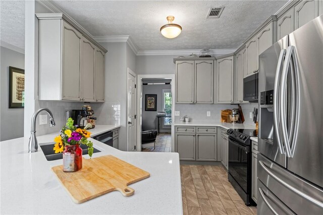 1630 Academy Dr Unit 402, Auburn, AL 36830 - kitchen with black appliances, gray cabinetry, backsplash, light countertops, and ornamental molding