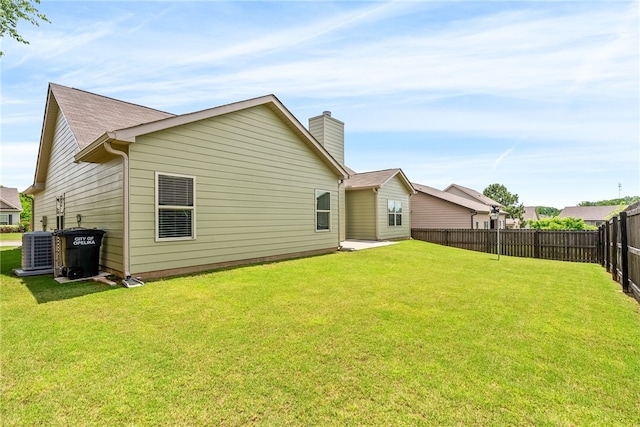 704 Lori Ln, Opelika, AL 36804 - rear view of house featuring central air condition unit and a chimney