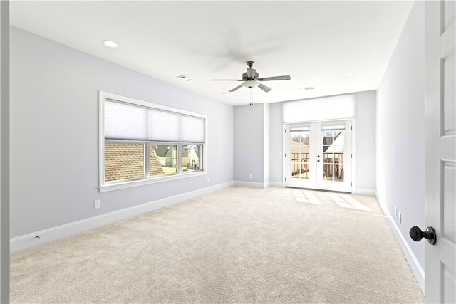 empty room featuring baseboards, french doors, a healthy amount of sunlight, and light colored carpet