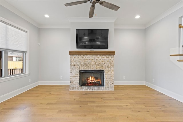 unfurnished living room with baseboards, a tile fireplace, light wood-style flooring, and crown molding