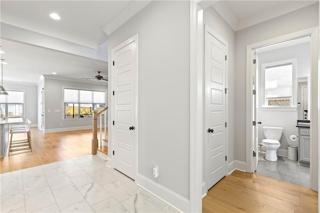 hall with stairs, light wood-style floors, baseboards, and crown molding