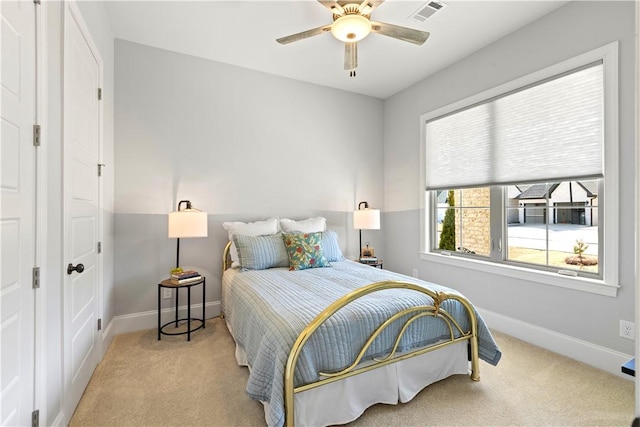 carpeted bedroom with a ceiling fan, visible vents, and baseboards