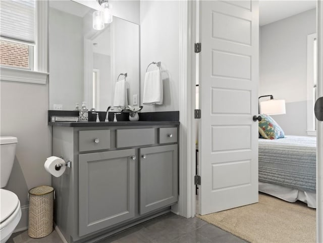 ensuite bathroom with toilet, vanity, and ensuite bath