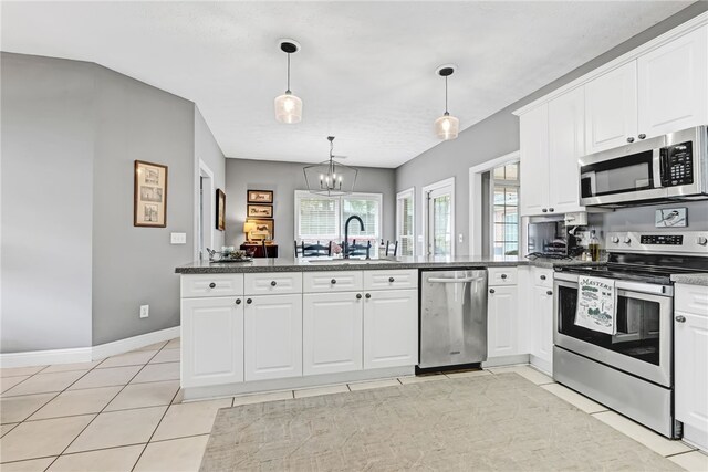1939 Windway Rd, Auburn, AL 36830 - kitchen featuring stainless steel appliances, a sink, a peninsula, white cabinetry, and decorative light fixtures