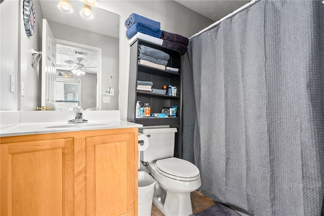 bathroom with ceiling fan, vanity, a textured ceiling, and toilet